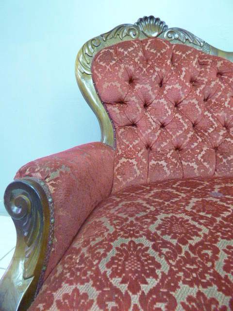 A spectacular hand carved Victorian couch with deep button detailing and rolled padded armrests!