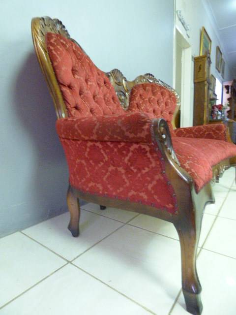 A spectacular hand carved Victorian couch with deep button detailing and rolled padded armrests!