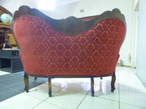 A spectacular hand carved Victorian couch with deep button detailing and rolled padded armrests!