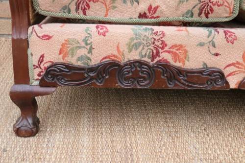 A wonderful antique hand carved ball and claw three-seater wicker-back sofa w/ upholstered cushions