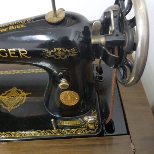 An incredible vintage (1930) singer "treadle" sewing machine in its cabinet in wonderful condition