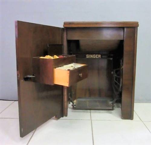 An incredible vintage (1930) singer "treadle" sewing machine in its cabinet in wonderful condition