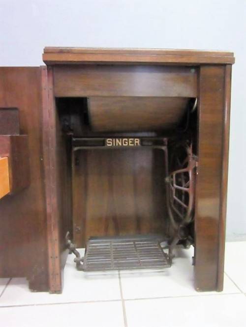 An incredible vintage (1930) singer "treadle" sewing machine in its cabinet in wonderful condition