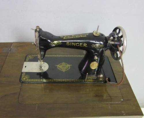 An incredible vintage (1930) singer "treadle" sewing machine in its cabinet in wonderful condition