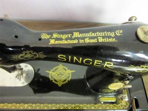 An incredible vintage (1930) singer "treadle" sewing machine in its cabinet in wonderful condition