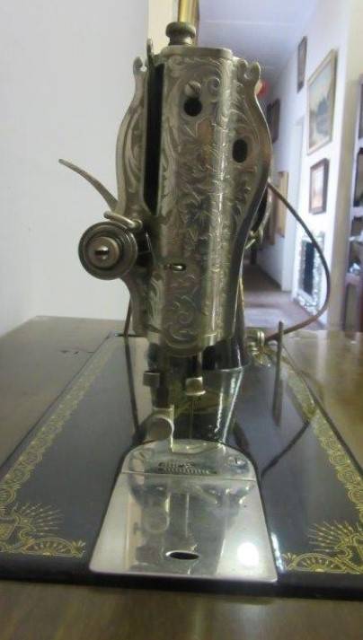 An incredible vintage (1930) singer "treadle" sewing machine in its cabinet in wonderful condition