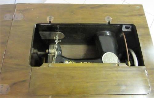 An incredible vintage (1930) singer "treadle" sewing machine in its cabinet in wonderful condition