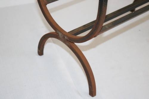 An awesome and well made wrought iron fireplace log holder with stunning "arrow" finials