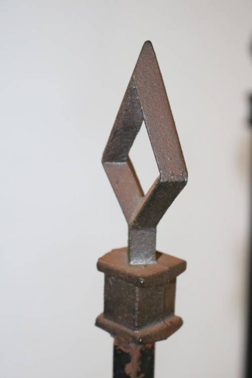 An awesome and well made wrought iron fireplace log holder with stunning "arrow" finials