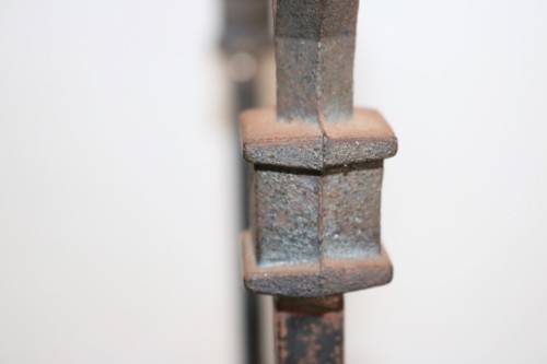 An awesome and well made wrought iron fireplace log holder with stunning "arrow" finials