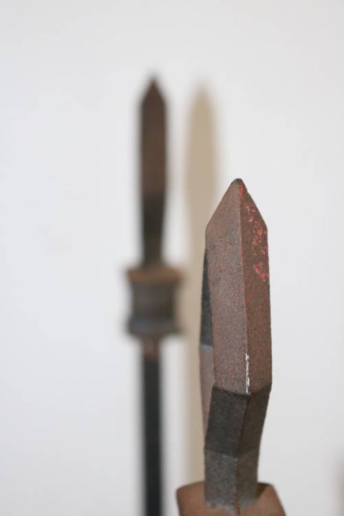 An awesome and well made wrought iron fireplace log holder with stunning "arrow" finials