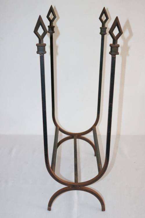 An awesome and well made wrought iron fireplace log holder with stunning "arrow" finials