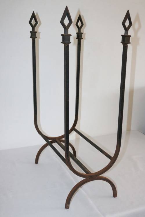 An awesome and well made wrought iron fireplace log holder with stunning "arrow" finials