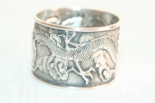 An incredible and rare Chinese solid silver "Dragon" napkin ring with amazing hand chased detailing