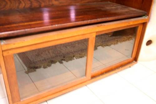 **RS17** A large Teak cabinet w/ fold away serving shelf, glass sliding doors, on original castors
