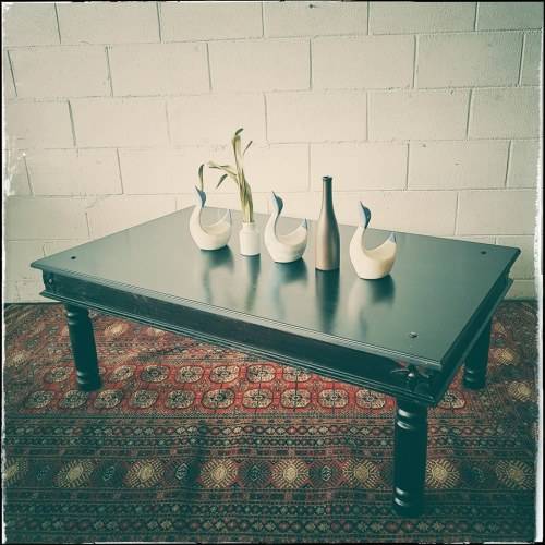 A stunning Indonesian Teak coffee table with clean lines, thick turned legs and carved detailing