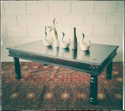 A stunning Indonesian Teak coffee table with clean lines, thick turned legs and carved detailing