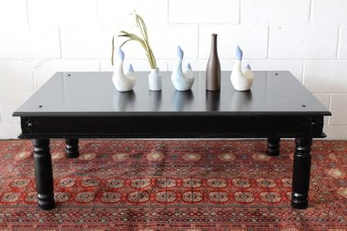 A stunning Indonesian Teak coffee table with clean lines, thick turned legs and carved detailing