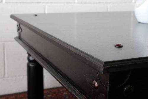 A stunning Indonesian Teak coffee table with clean lines, thick turned legs and carved detailing