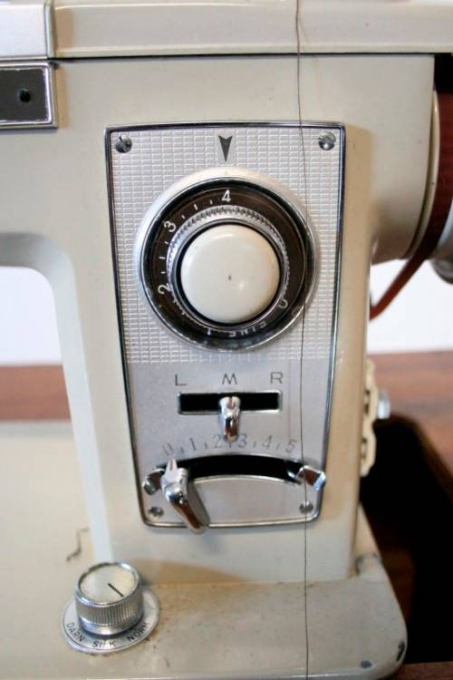A vintage Empisal deluxe electric sewing machine in its original cabinet w/ accessories, working.
