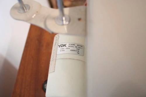 A vintage Empisal deluxe electric sewing machine in its original cabinet w/ accessories, working.