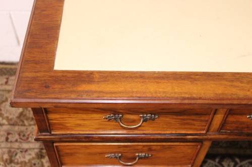 A beautiful vintage knee-hole writing desk w/ an off-white leather top & 9x drawers w/ brass handles