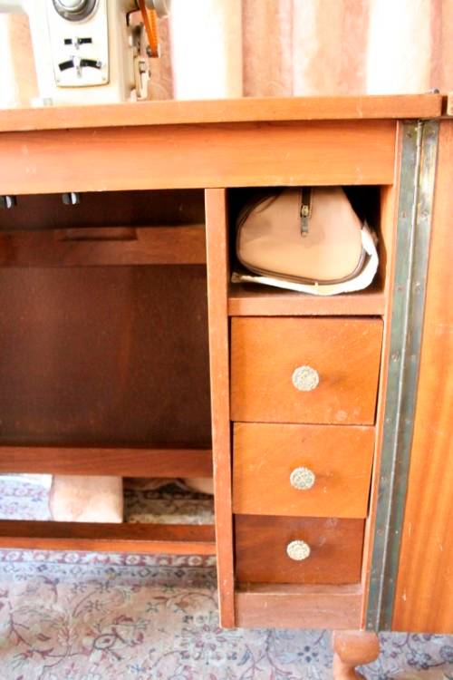 A vintage Empisal deluxe electric sewing machine in its original cabinet w/ accessories, working.