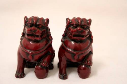 A gorgeous pair of cinnabar-red resin foo dogs/ temple lions in lovely condition