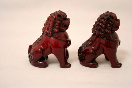 A gorgeous pair of cinnabar-red resin foo dogs/ temple lions in lovely condition