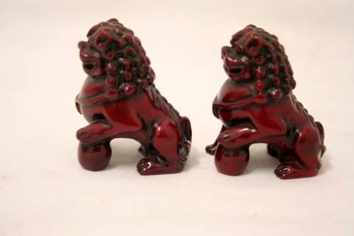 A gorgeous pair of cinnabar-red resin foo dogs/ temple lions in lovely condition