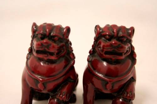 A gorgeous pair of cinnabar-red resin foo dogs/ temple lions in lovely condition