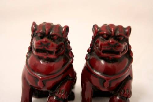 A gorgeous pair of cinnabar-red resin foo dogs/ temple lions in lovely condition