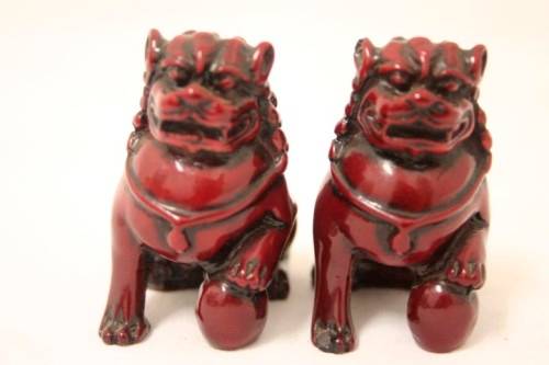 A gorgeous pair of cinnabar-red resin foo dogs/ temple lions in lovely condition