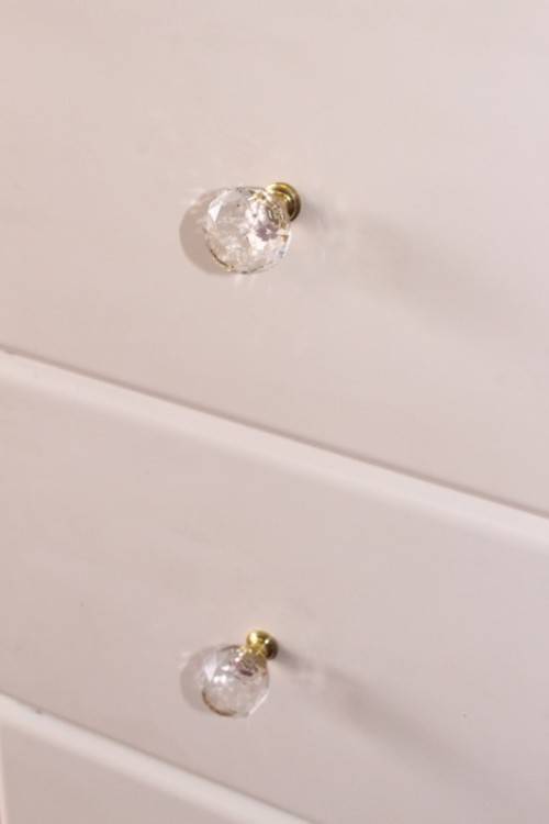 A stunning white 5-drawer chest of drawers with crystal/ glass? handles and ample storage space