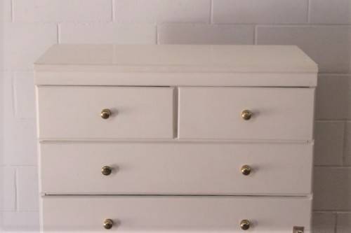 A tall 4-over-2 white painted chest of drawers with brass handles and ample storage space