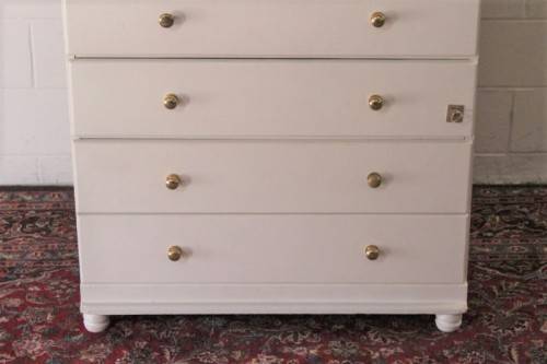 A tall 4-over-2 white painted chest of drawers with brass handles and ample storage space
