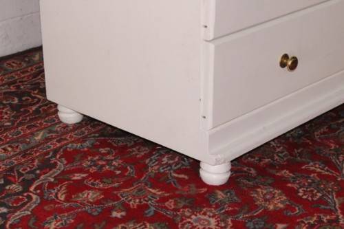 A tall 4-over-2 white painted chest of drawers with brass handles and ample storage space