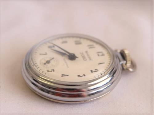 A gorgeous antique Canadian made Westclox Zobo chrome plated open-face pocket watch with a fob chain