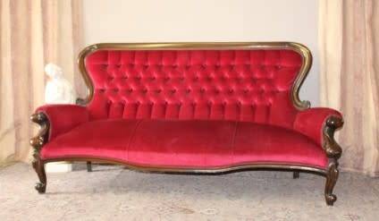 A gorgeous antique Victorian 3 seater settee couch w carved detailing and period style upholstery.