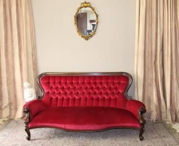 A gorgeous antique Victorian 3 seater settee couch w carved detailing and period style upholstery.
