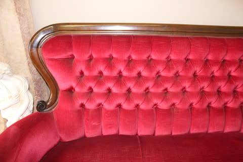 A gorgeous antique Victorian 3 seater settee couch w carved detailing and period style upholstery.