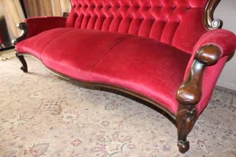 A gorgeous antique Victorian 3 seater settee couch w carved detailing and period style upholstery.