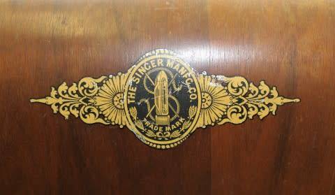 An amazing antique (1910) Singer hand cranked sewing machine in its original casing.