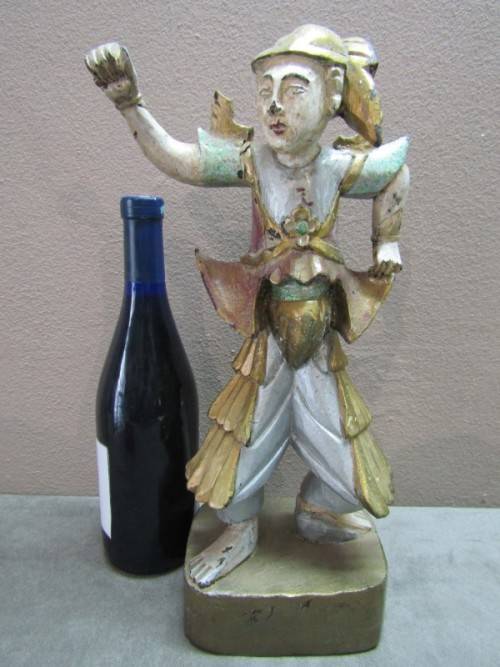 A carved ornamental Oriental wood figurine in traditional dress on a wood base. Lifespace Sale