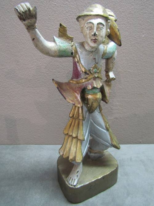 A carved ornamental Oriental wood figurine in traditional dress on a wood base. Lifespace Sale