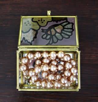 A charming coloured glass trinket box with a gold-coloured frame and mirror base. Lifespace Sale