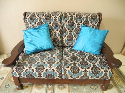 A colourful blue vintage Imbuia 2 seater couch - perfect in a lounge/patio/lapa.