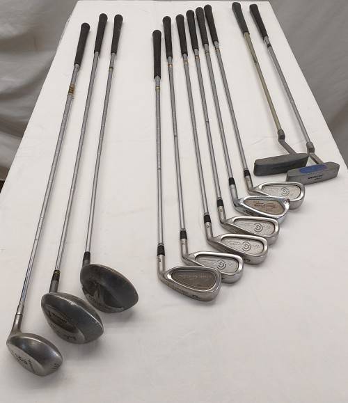 A collection of 11x assorted golf clubs, including irons, woods/ drivers and two putters