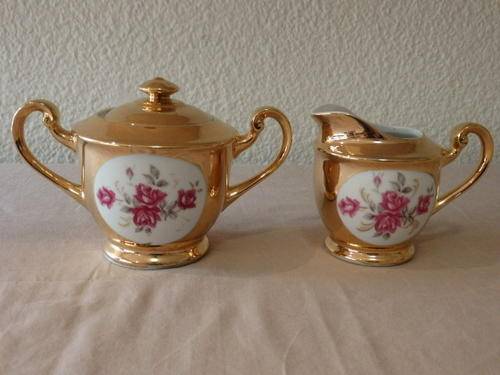 A STUNNING BONE CHINA MILK JUG AND SUGAR BOWL WITH A BROAD GOLD GILDED RIM AND DAINTY PINK FLOWERS