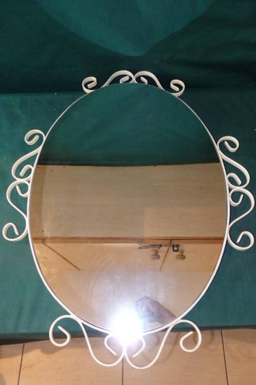 A FANTASTIC LARGE OVAL MIRROR IN A WHITE METAL FRAME WITH "TWIRLED" DESIGN VECTORS